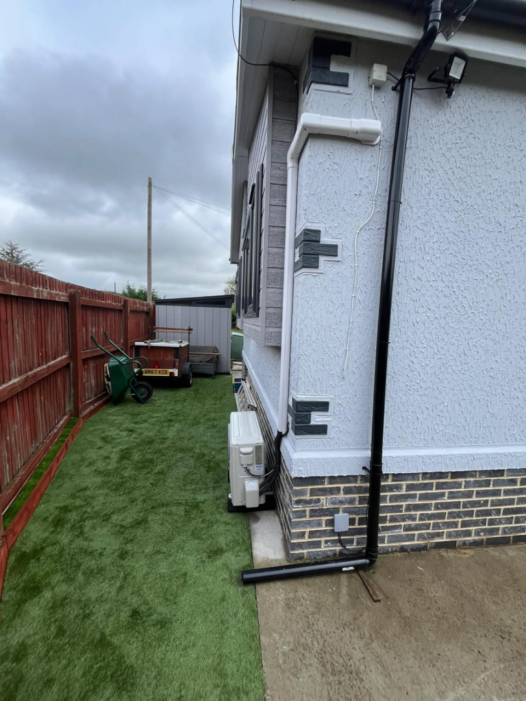 Outdoor air conditioning unit and pipework fitted to the side of a house